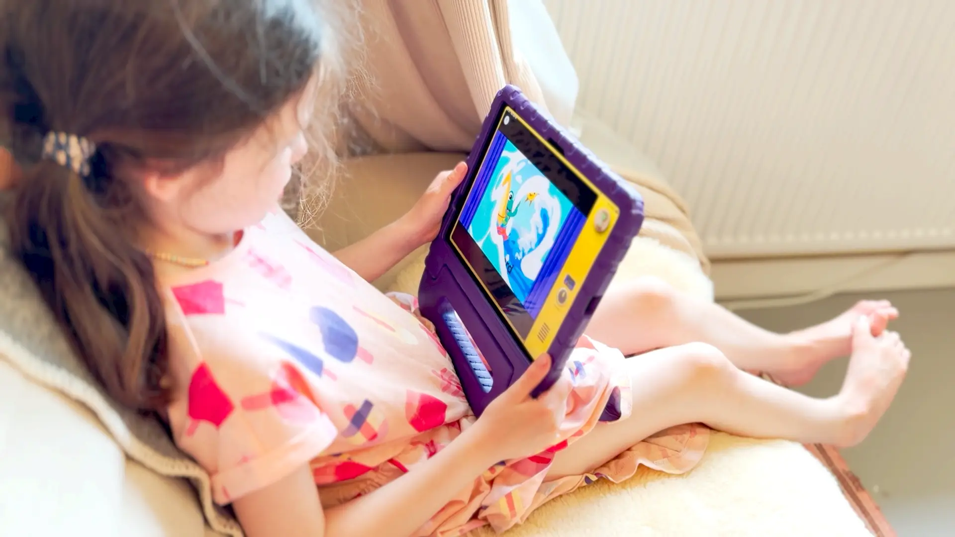 A child watching a claymation Meevee story on a tablet in bed
